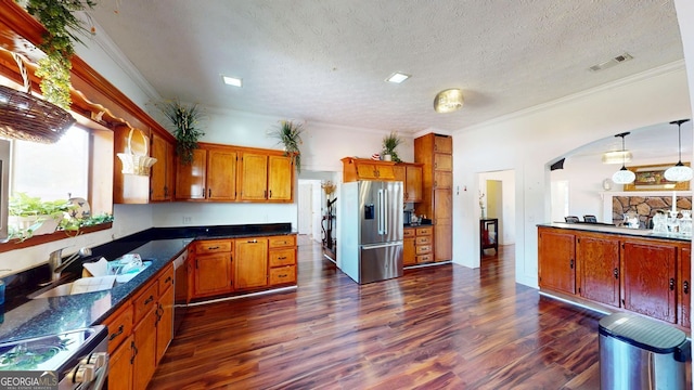 kitchen with appliances with stainless steel finishes, dark hardwood / wood-style floors, pendant lighting, sink, and ornamental molding