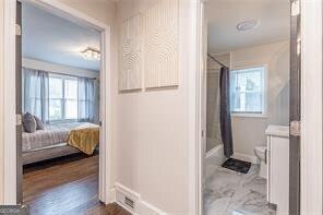 bathroom with shower / bath combination with curtain, toilet, and hardwood / wood-style flooring