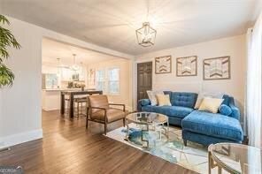 living room with an inviting chandelier and dark hardwood / wood-style flooring