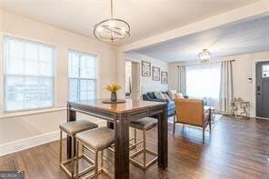 dining area featuring beamed ceiling and dark hardwood / wood-style floors