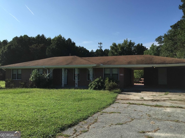 ranch-style house featuring a carport and a front lawn