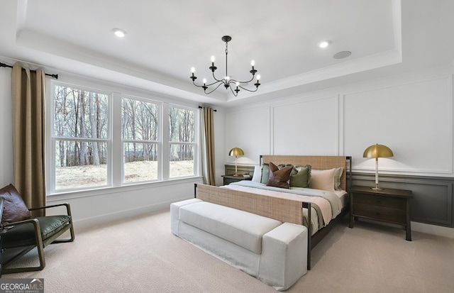 carpeted bedroom with an inviting chandelier, a tray ceiling, and crown molding