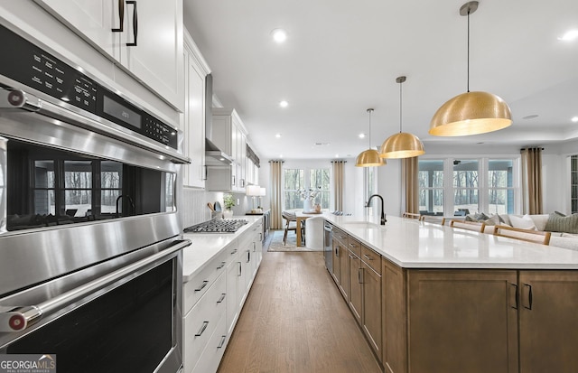 kitchen featuring white cabinetry, pendant lighting, a spacious island, and appliances with stainless steel finishes