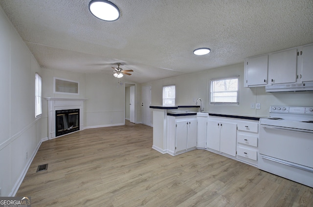 kitchen featuring white electric stove, white cabinetry, ceiling fan, a textured ceiling, and light hardwood / wood-style flooring