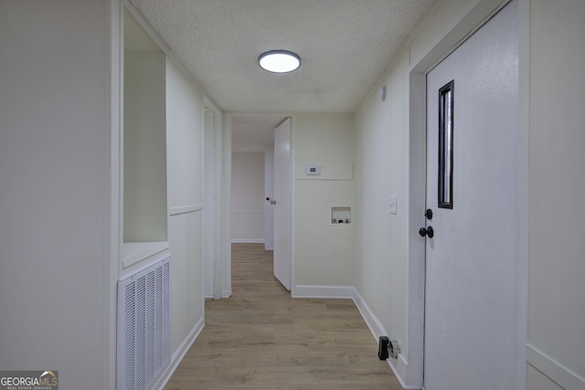 hallway featuring a textured ceiling and light wood-type flooring