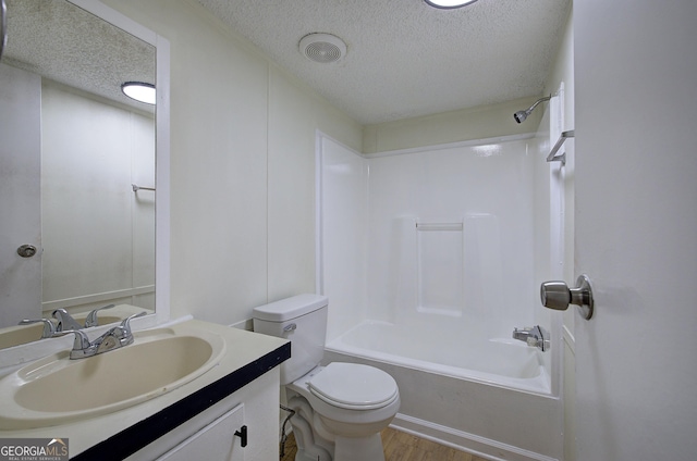 full bathroom featuring vanity, toilet, shower / bathing tub combination, and a textured ceiling