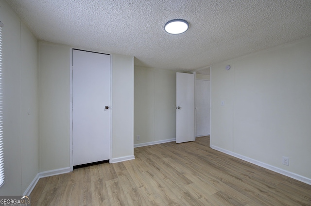 unfurnished bedroom featuring light hardwood / wood-style floors and a textured ceiling