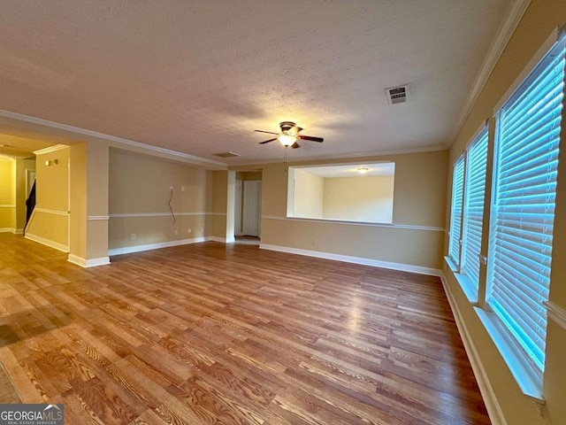 unfurnished living room featuring ceiling fan, ornamental molding, hardwood / wood-style floors, and a textured ceiling