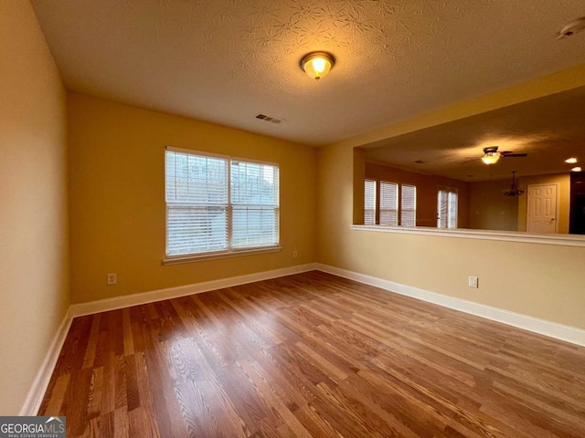 spare room featuring wood-type flooring and a textured ceiling