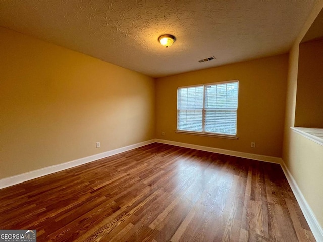 empty room featuring hardwood / wood-style floors and a textured ceiling