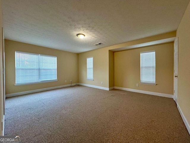 unfurnished room with carpet floors and a textured ceiling