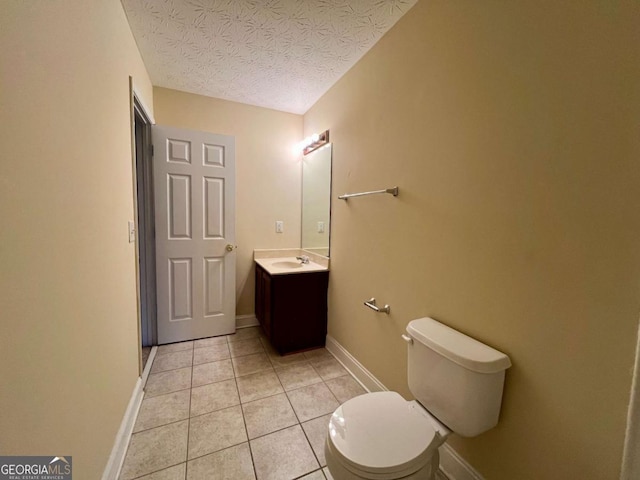 bathroom featuring vanity, toilet, tile patterned flooring, and a textured ceiling