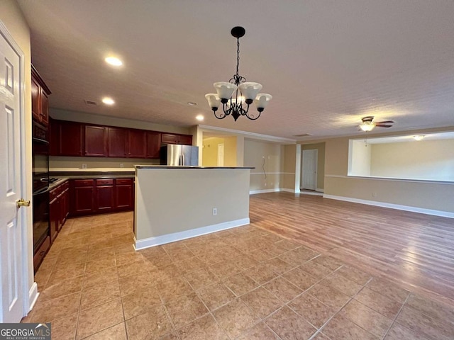 kitchen with light tile patterned floors, stainless steel refrigerator, a kitchen island, pendant lighting, and ceiling fan with notable chandelier