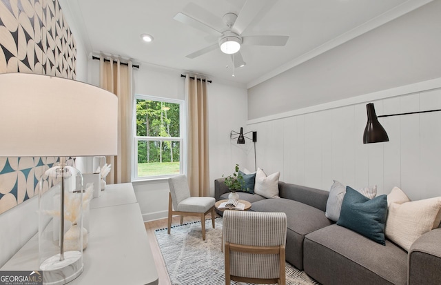 living room with hardwood / wood-style flooring, ornamental molding, and ceiling fan