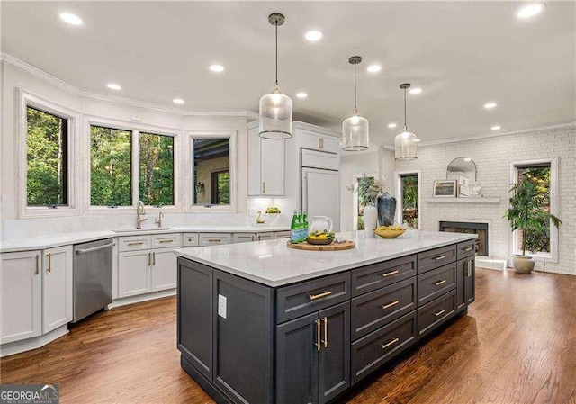 kitchen with white cabinetry, stainless steel dishwasher, and decorative light fixtures