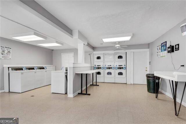 community laundry room featuring washing machine and dryer, light floors, baseboards, and stacked washing maching and dryer