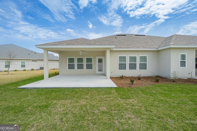 rear view of house featuring ceiling fan, a patio area, and a lawn