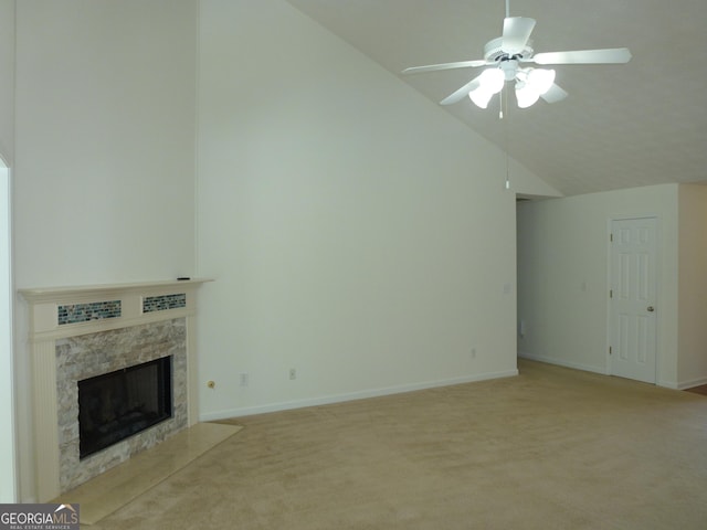 unfurnished living room with light colored carpet, a high end fireplace, ceiling fan, high vaulted ceiling, and baseboards