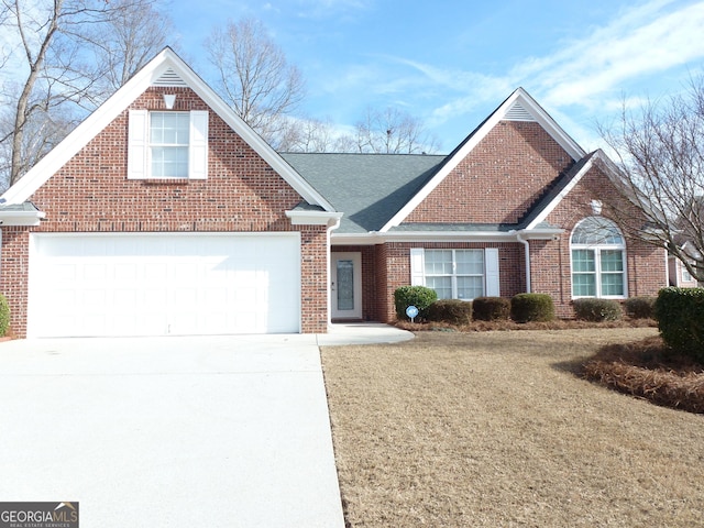 view of front facade featuring driveway, a shingled roof, a garage, and brick siding