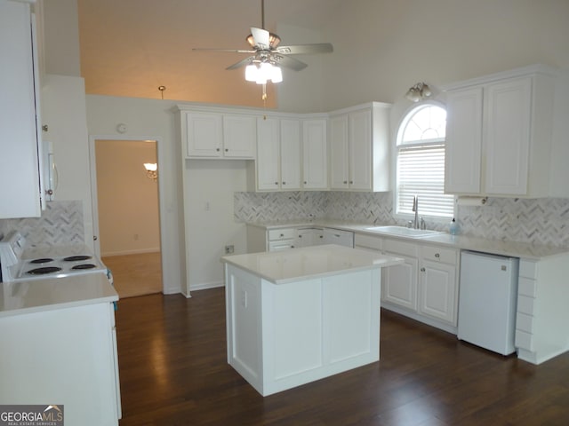 kitchen featuring light countertops, white appliances, white cabinets, and a sink