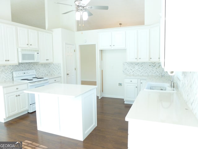 kitchen with white appliances, white cabinets, and light countertops