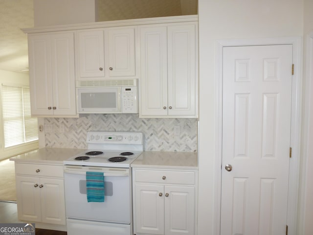 kitchen with light countertops, white appliances, and white cabinetry