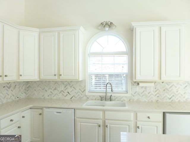 kitchen featuring light countertops, white dishwasher, a sink, and white cabinetry