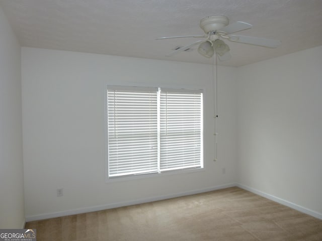 unfurnished room with ceiling fan, baseboards, and light colored carpet