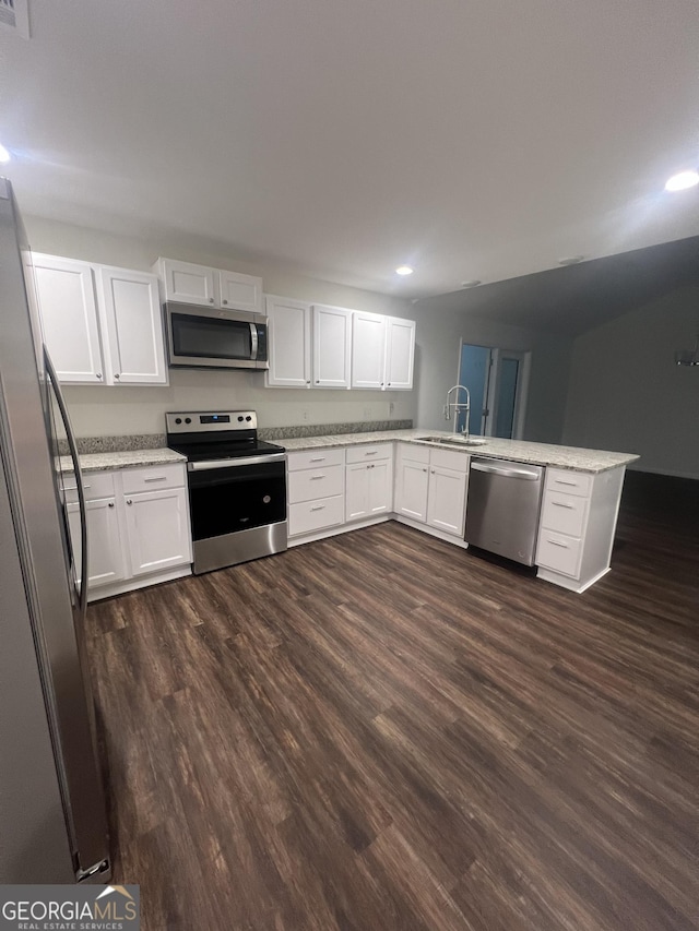 kitchen with white cabinetry, sink, kitchen peninsula, and appliances with stainless steel finishes