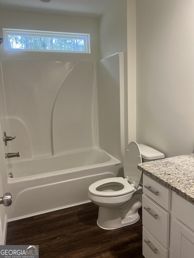 full bathroom featuring wood-type flooring, vanity, shower / bathtub combination, and toilet