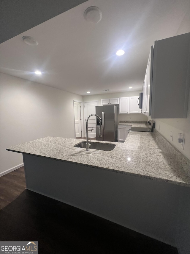 kitchen featuring sink, white cabinetry, dark hardwood / wood-style flooring, kitchen peninsula, and stainless steel appliances