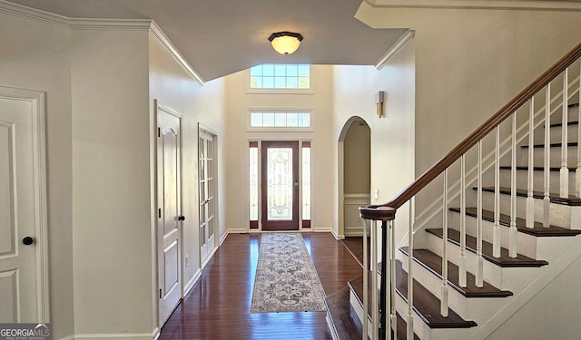 foyer with ornamental molding, lofted ceiling, and dark hardwood / wood-style floors