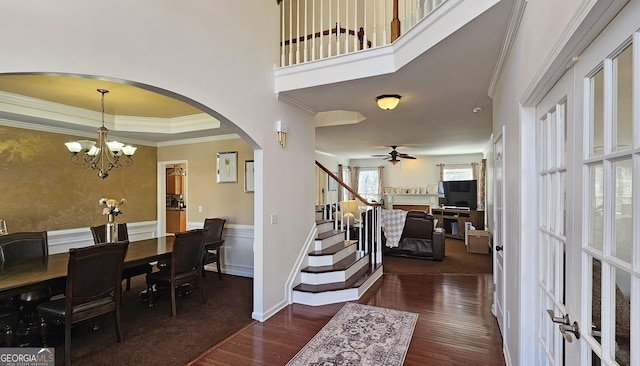 foyer featuring crown molding, dark hardwood / wood-style floors, and ceiling fan with notable chandelier