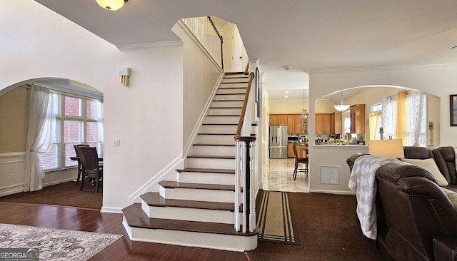 stairway with crown molding and hardwood / wood-style flooring