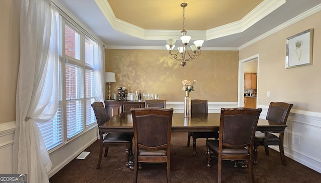 carpeted dining area featuring a raised ceiling, crown molding, and a notable chandelier