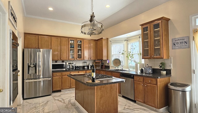 kitchen featuring sink, hanging light fixtures, a kitchen island, stainless steel appliances, and decorative backsplash