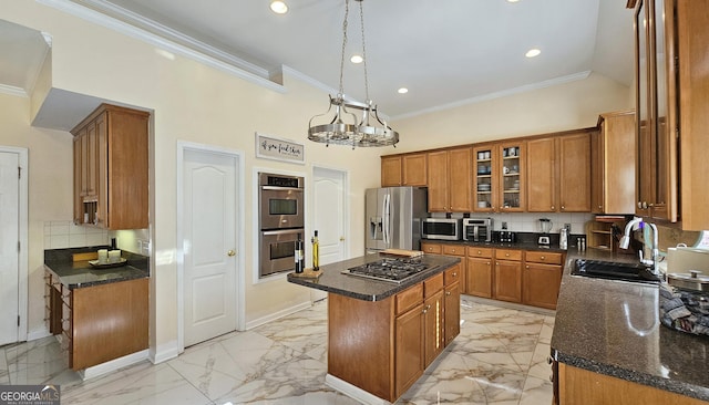 kitchen featuring sink, backsplash, stainless steel appliances, a kitchen island, and decorative light fixtures