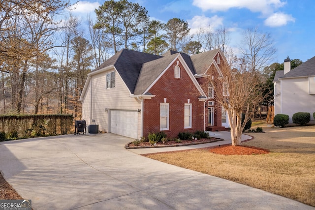 view of front property with a garage, cooling unit, and a front yard