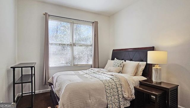 bedroom featuring multiple windows and dark hardwood / wood-style floors