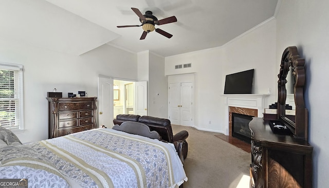 bedroom featuring ornamental molding, carpet floors, a closet, ceiling fan, and a fireplace