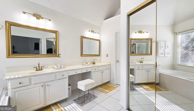 bathroom featuring vanity, tile patterned flooring, vaulted ceiling, and tiled tub