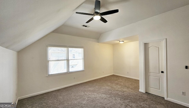 interior space featuring ceiling fan, lofted ceiling, and dark carpet