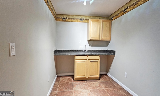 kitchen featuring light brown cabinetry, sink, and light tile patterned flooring