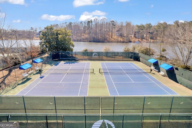 view of tennis court featuring a water view