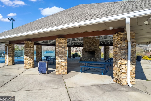 view of patio featuring a gazebo and an outdoor stone fireplace