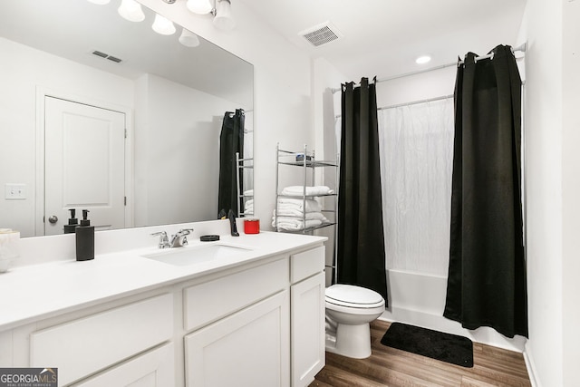 full bathroom featuring vanity, wood-type flooring, shower / bath combination with curtain, and toilet