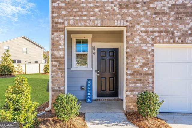 property entrance with a garage and a lawn