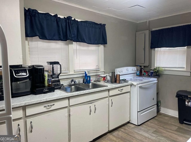 kitchen with white range with electric stovetop, sink, white cabinets, ornamental molding, and light hardwood / wood-style flooring