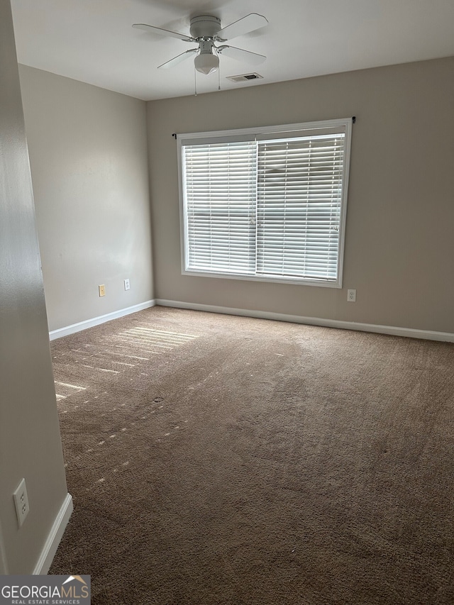 carpeted empty room featuring ceiling fan