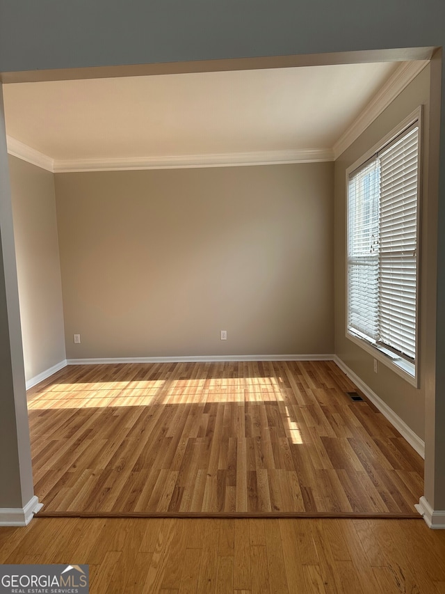 spare room featuring ornamental molding and wood-type flooring